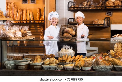 Beautiful Women Selling Fresh Pastry And Loaves In Bread Section And Smiling