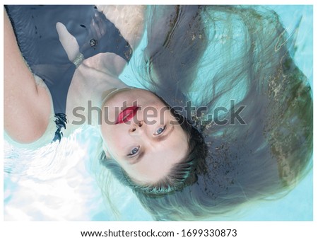 Similar – Woman face lying down over hands with colorful sparkles in skin