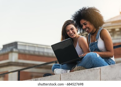 Beautiful women using a laptop in the Street. Youth concept.