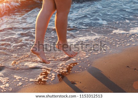 beautiful women's bare feet by the sea on the waves relaxation concept