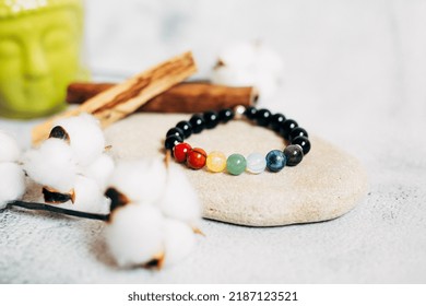 beautiful women's bracelet made of natural stones chakra color next to palo santo cotton flowers on a white background. women's accessories. accessories background. handmade jewelry.