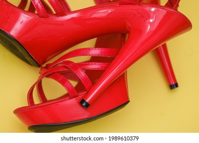 Beautiful Womens Shiny Patent Red Stiletto Sandals On Yellow Background 
