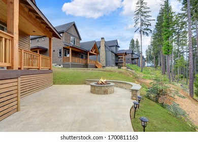 Beautiful Wooden Back Porch With Chairs On The Hill And Large Backyard Patio With Fire Pit And Pine Trees.