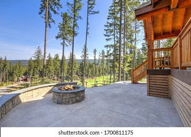 Beautiful Wooden Back Porch With Chairs On The Hill And Large Backyard Patio With Fire Pit And Pine Trees.