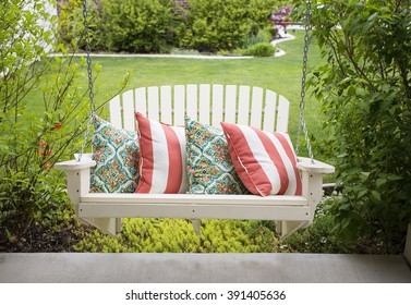 Beautiful wooden front porch swing with comfortable pillows