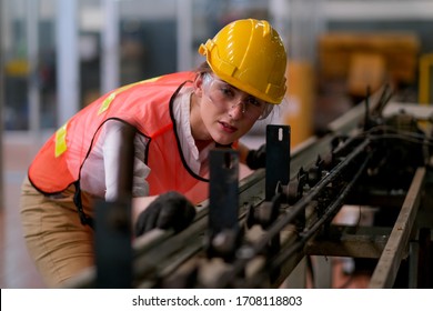 Beautiful Worker Or Technician Woman Look Forward Through Rail Of Some Machine In Factory Work.