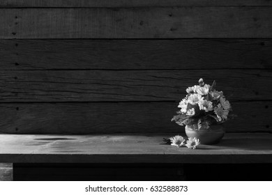 Beautiful yellow flowers with green leaf in the ceramics vase put on the plank in dim light room / Still life image and selective focus, visual art, Space for text, black and white image

 - Powered by Shutterstock