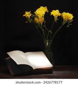 Beautiful yellow freesia flowers near book on dark table, space for text - Powered by Shutterstock