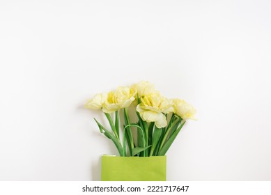 Beautiful Yellow Tulip Flowers In A Green Paper Bag With Space For Text. The Concept Of Sales, Spring Discounts, Shopping And Environmentally Friendly Packaging.