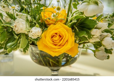 Beautiful Yellow And White Roses Bouquet In Glass Vase On White Linen Table Cloth