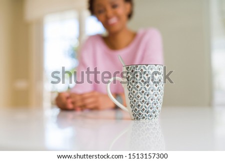 Beautiful youn woman with afro hair drinking a cup of coffee