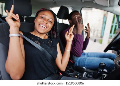 Beautiful Young African American Couple Sitting On The Front Passenger Seats While Handsome Man Driving A Car. Listening Music And Dance.