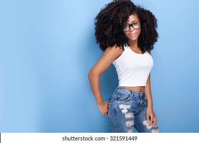 Beautiful young african american girl posing in studio, looking at camera.