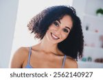 Beautiful young African American woman smiling in sporty attire indoors, exuding happiness and health.