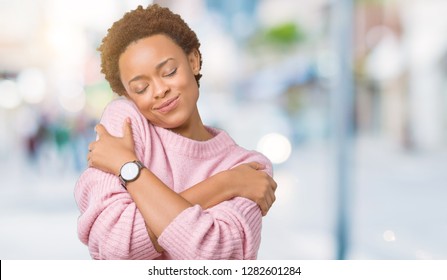 Beautiful young african american woman over isolated background Hugging oneself happy and positive, smiling confident. Self love and self care - Shutterstock ID 1282601284