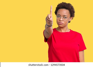 Beautiful young african american woman wearing glasses over isolated background Pointing with finger up and angry expression