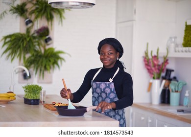 Beautiful Young African American Woman Is Cooking At The Kitchen