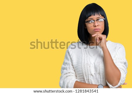 Beautiful young african american woman wearing glasses over isolated background looking confident at the camera with smile with crossed arms and hand raised on chin. Thinking positive.