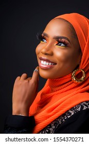 Beautiful Young African Muslim Woman Wearing An Orange Hijab And Black Dress And Makeup Smiling Looking Stunning And Fashionable