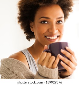 Beautiful young African woman enjoying a cup of coffee.