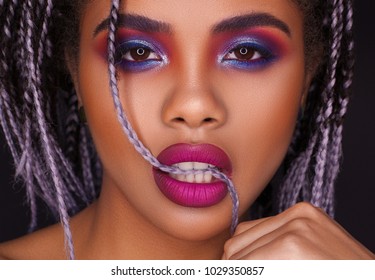 Beautiful young African woman with fashion makeup on black
