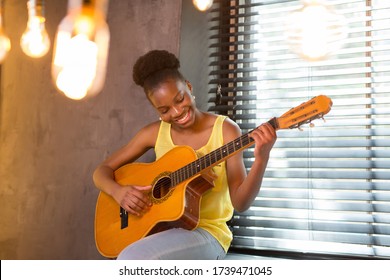 Beautiful Young African Woman Playing Guitar