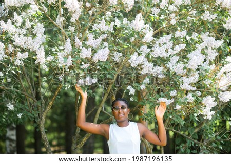 beautiful young african woman with spring flowers on the tree	
