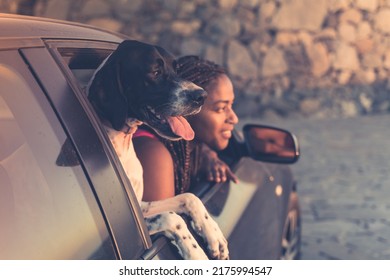 Beautiful Young African Woman Travels In The Car With Her Dog. On The Concept Of Summer Road Trip Holiday.