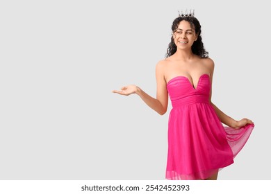 Beautiful young African-American woman in stylish pink prom dress and tiara on grey background - Powered by Shutterstock