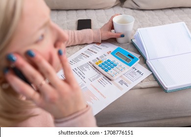 Beautiful young Albino woman sitting with calculator and bills, doing paperwork. Hand woman doing finances and calculate on desk about cost at home office.Concept work from home - Shutterstock ID 1708776151