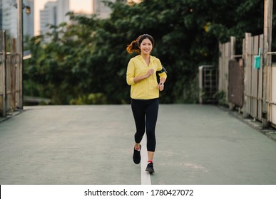 Beautiful Young Asia Athlete Lady Running Exercises Work Out In Urban Environment. Japanese Teen Girl Wearing Sports Clothes On Walkway Bridge In Early Morning. Lifestyle Active Sporty In City.