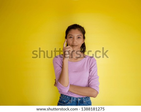 beautiful young asia woman against yellow wall.