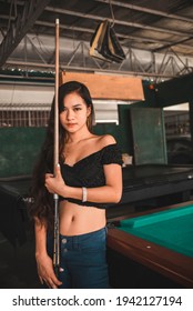 A Beautiful And Young Asian Billiard Player At An Open Air And Old Pool Hall. Third World And Exotic Ambiance.