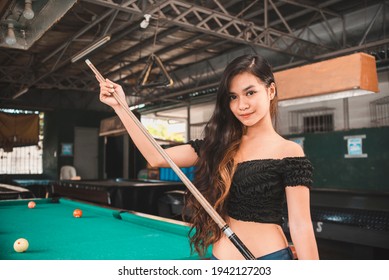 A Beautiful And Young Asian Billiard Player At An Open Air And Old Pool Hall. Third World And Exotic Ambiance.