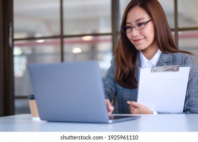 A Beautiful Young Asian Business Woman Using Laptop Computer While Working In Office