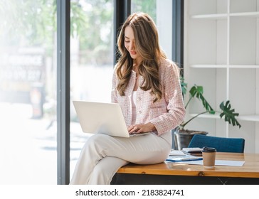 Beautiful Young Asian Business Woman Using Laptop Computer In Her Office Workplace.