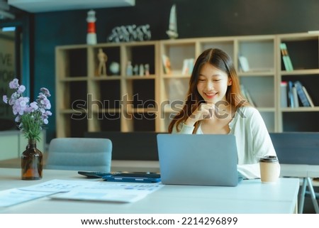 Beautiful young Asian businesswoman working at workspace.