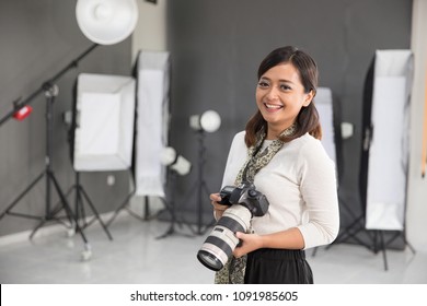 Beautiful Young Asian Female Photographer Standing In Studio