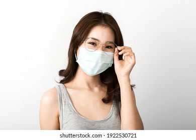 A Beautiful Young Asian Girl With Glasses Wearing A Face Mask To Protect The Pollution Or Covid19 Virus Disease. White Background In The Studio. Healthcare Pollution And Virus Pandemic Concept.