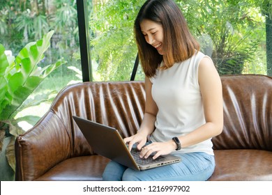 Beautiful Young Asian Girl Working At A Coffee Shop With A Laptop.female Freelancer Connecting To Internet Via Computer.