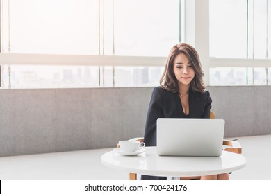 Beautiful young Asian girl working at a office space with a laptop. Concept of smart female business.Vintage tone