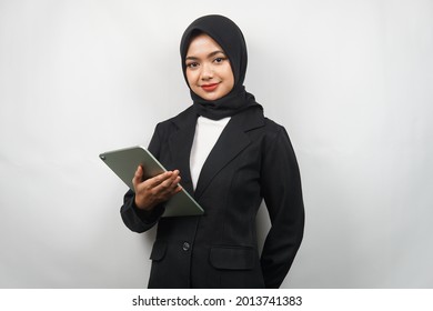 Beautiful Young Asian Muslim Business Woman Confident And Smiling, With Hands Holding Tablet, Time To Work, Productive Time, Isolated On Gray Background