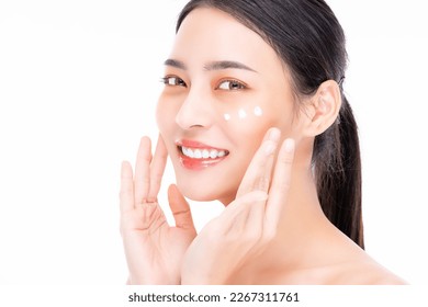 Beautiful Young Asian Woman applying cosmetic treatment cream on beauty face isolated on white background Beautiful smiling asia model portrait with natural make up She touching glowing moist skin