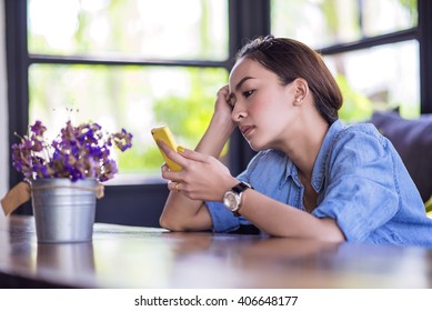 Beautiful Young Asian Woman Being Lonely Waiting For The Phone In Coffee Shop