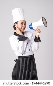 Beautiful young asian woman chef holding megaphone on white background.
