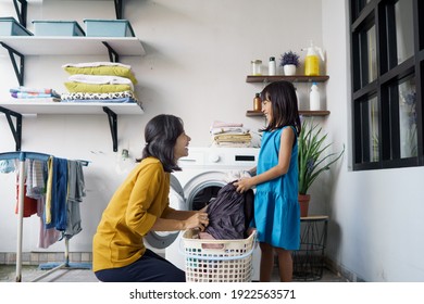 Beautiful Young Asian Woman And Child Girl Little Helper Are Doing Laundry At Home.