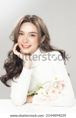 Beautiful young asian woman with clean fresh skin on grey background. Female model wearing white turtleneck Long sleeves Face care, Facial treatment, Cosmetology, beauty and spa, women portrait.