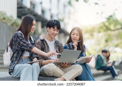 Beautiful young Asian woman college student with friends at outdoors. College student working on the college campus - Powered by Shutterstock