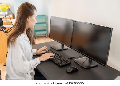 Beautiful young asian woman editing on a computer