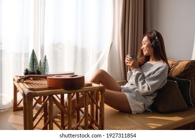 A Beautiful Young Asian Woman Enjoy Drinking Coffee And Listening To Music With Headphone At Home